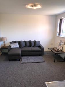 a living room with a couch and two tables at Driftwood Apartment - Skegness in Skegness