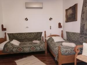 uma sala de estar com duas camas e uma cadeira em Míves Vendégház em Pogány