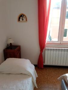 - une chambre avec un lit et une fenêtre avec un rideau rouge dans l'établissement Da Cesare, à Moneglia