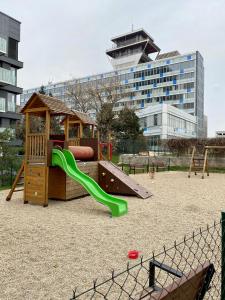 a playground with a green slide in a park at Apartment David Garden Towers in Prague