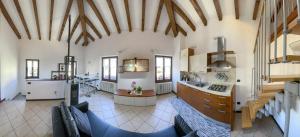 a large kitchen and living room with wooden ceilings at Da Perry in Morbegno