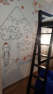 a bedroom with a wall with a drawing of a boy and clouds at Geography Hostel Kazan in Kazan