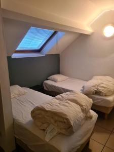 two beds in a room with a window at 6-8 pers appartement Résidence Durbuy in Durbuy