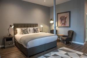 1 dormitorio con cama, escritorio y silla en The Townhouse Aberfeldy en Aberfeldy