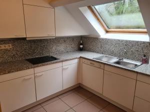 a kitchen with white cabinets and a sink and a window at 6-8 pers appartement Résidence Durbuy in Durbuy