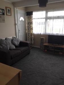 een woonkamer met een bank en een flatscreen-tv bij 2 bed dog friendly chalet on sunbeach Scratby in Great Yarmouth