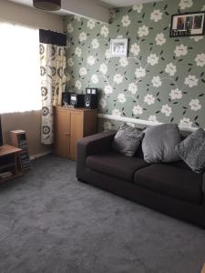 een woonkamer met een bank en een muur met vlinders bij 2 bed dog friendly chalet on sunbeach Scratby in Great Yarmouth