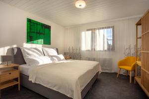 ein Schlafzimmer mit einem großen Bett und einem gelben Stuhl in der Unterkunft Ferienhaus Villa Milla Nürnberg in Nürnberg