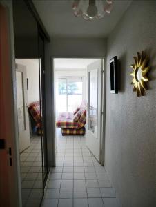 un pasillo con una habitación con sofá y ventana en Appartement en RDC avec terrasse face a la mer, en Pornic