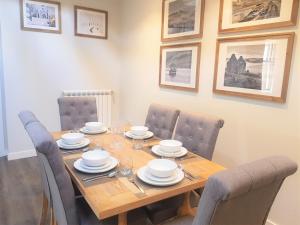 a dining room table and chairs with a wooden table and plates at Hunters Holiday Cottage in Saint Boswells