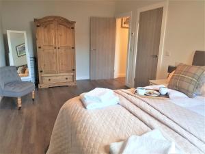 a bedroom with a bed with a tray of food on it at Hunters Holiday Cottage in Saint Boswells