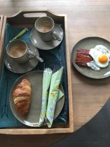 a tray with plates of breakfast food and a cup of coffee at B&B Den Biesthoek in Grimbergen