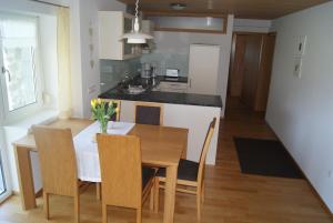 a kitchen and dining room with a table and chairs at Haus Eberle in Hittisau