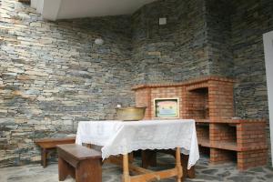 a stone room with a table and a brick wall at Casa Dos Xarês in Rosmaninhal