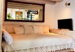 sypialnia z łóżkiem z lustrem i telewizorem w obiekcie JUDERIA LUXURY SUITE Casas Vejer Debra w mieście Vejer de la Frontera