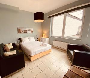 - une chambre avec un lit, un canapé et une fenêtre dans l'établissement Fenêtre sur le Standard de Liège, à Ougrée