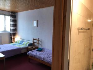 a bedroom with two beds and a door to a bathroom at Guest house Pizzeria Pazza da Gianni in Stein am Rhein