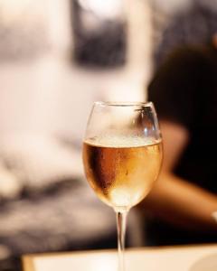 a glass of white wine sitting on a table at Villa Livia Boutique Apartments in Ravda