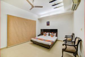新德里的住宿－FabHotel Exotica Greenpark，一间卧室配有一张床和一把椅子