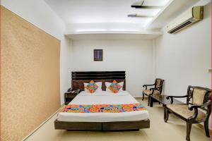 新德里的住宿－FabHotel Exotica Greenpark，一间卧室配有一张床和两把椅子