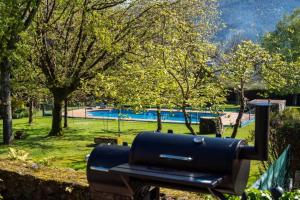 una barbacoa negra en un parque con piscina en Villa Ponte Bora, en Pontevedra