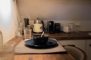 a table with a plate and a coffee maker on it at B&B Pont in Wessem
