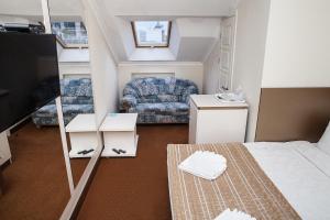 a small room with a couch and a tv at 7 Sky on Yevhena Konovaltsia in Kyiv