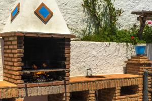 a brick pizza oven with a fire in it at Malaga mountains winehouse with private pool in Borge