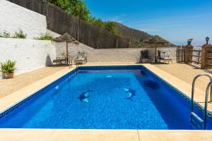 una piscina de agua azul en una casa en Malaga mountains winehouse with private pool, en Borge