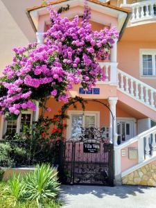 dom z różowymi kwiatami wiszącymi nad bramą w obiekcie Hotel Villa Vera w Fažanie