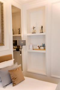 1 dormitorio con paredes blancas y estanterías blancas en Bon Hotel, en Dnipro