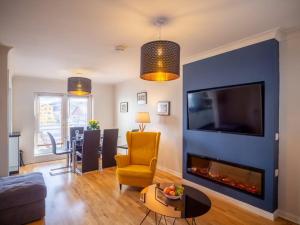 a living room with a blue wall with a fireplace at Rosies in Clifden
