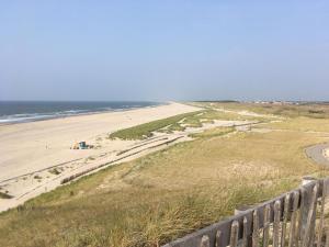 vista su una spiaggia con recinzione e oceano di Eb & Vloed a Petten