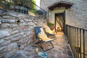 a patio with two chairs and a stone wall at Residence Menotre in Rasiglia