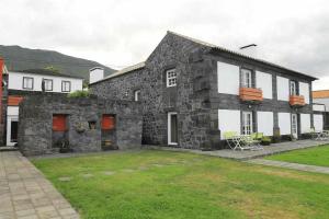 un gran edificio de piedra con un patio delante en A Casa do Ouvidor, en São Roque do Pico