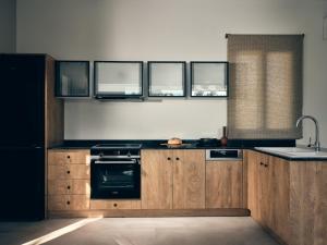 a kitchen with wooden cabinets and a sink and a stove at Oceanids Luxury Villas, By ThinkVilla in Vasilikos