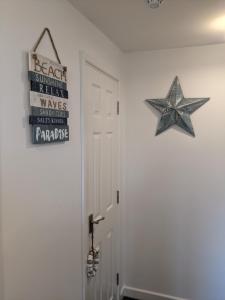 a door with a star and a sign on the wall at Driftwood Apartment - Skegness in Skegness