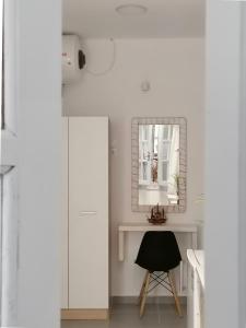um quarto branco com um espelho e uma cadeira em Aura Skiathos em Skiathos