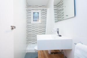 a white bathroom with a sink and a toilet at Autèntic Arc de Triomf Apartment in Barcelona