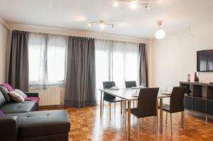 uma sala de estar com uma mesa e cadeiras e um sofá em Autèntic Arc de Triomf Apartment em Barcelona