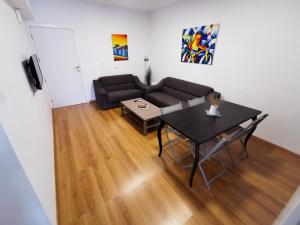una sala de estar con un sofá y una mesa en Daze Off Central Apartment, 300m to the Finikoudes Beach, en Lárnaca