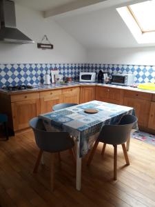 a kitchen with a table with chairs and a counter at gite du montagnard in Oxelaere