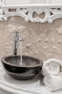 La salle de bains est pourvue d'un lavabo noir et d'un miroir. dans l'établissement Au Bourg Neuf, à Orléans