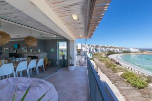 a patio with a table and a view of the ocean at Sandy Toes Beach Villa in Langebaan