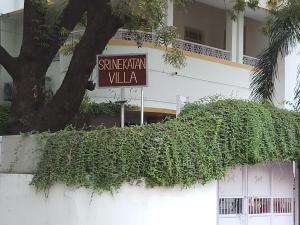a ivy covered wall with a street sign in front of a building at Srinekatan Heritage Villa Homestay in Ahmedabad