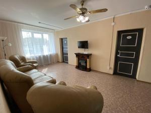 a living room with a couch and a ceiling fan at Хостел Декабрист in Chita