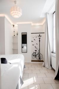 a white bedroom with a bed and a bike on the wall at Au Bourg Neuf in Orléans
