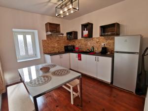 a kitchen with a table and a white refrigerator at Chambres d'Hôtes Ene Gutizia in Ustaritz
