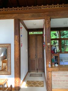 Habitación con puerta de madera y espejo. en Guest House Tânia Alves en Pratinha