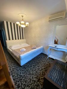 ein kleines Schlafzimmer mit einem Bett und einem Spiegel in der Unterkunft Hanu Satului in Constanţa